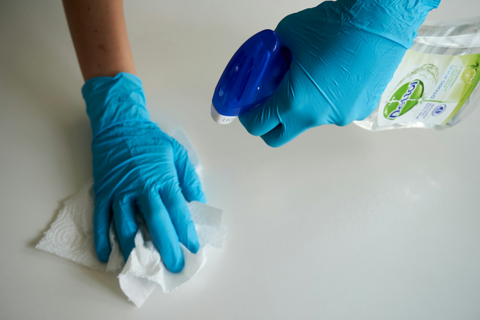 Reinigungskraft mit Handschuhen bei der Flächenreinigung